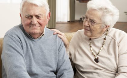 Senior Woman Consoling Husband At Home