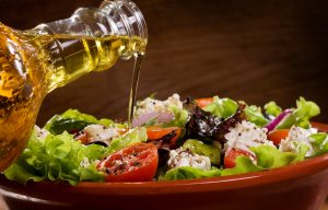 Vegetable salad with olive oil pouring