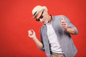 Portrait of senior happy cheerful elderly man dancing and listen